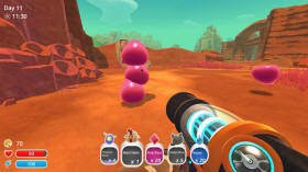 Some pink slimes in Slime Rancher playing together as they balance on top of one another.